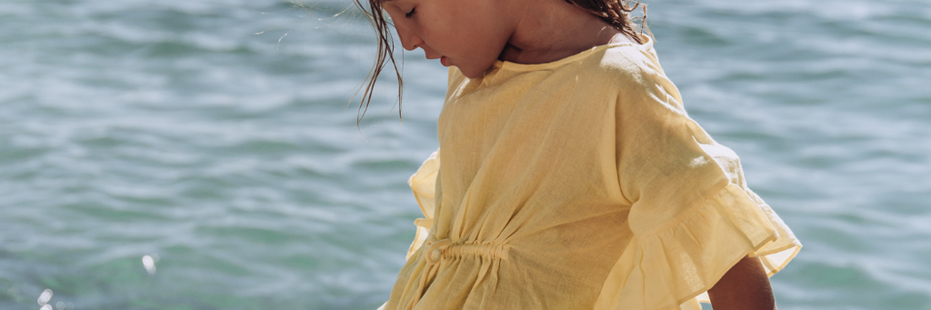 Little girl on the beach wearing Lison Paris cover-up kaftan