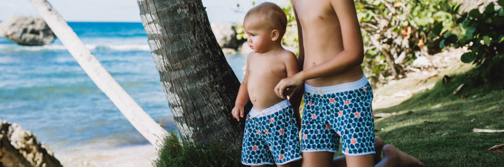 Baby wearing Folpetto swim shorts and matching with his brother