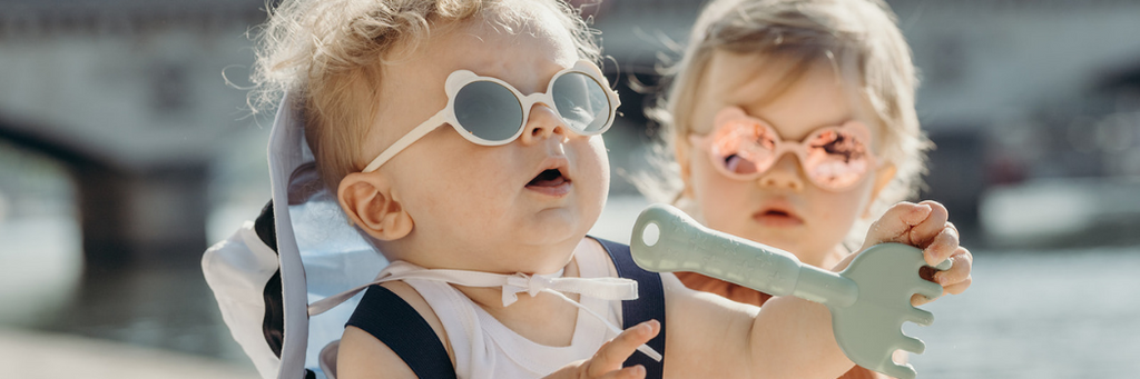 Two little babies wearing their Ki et la Ourson teddy bear children's sunglasses in the sunshine