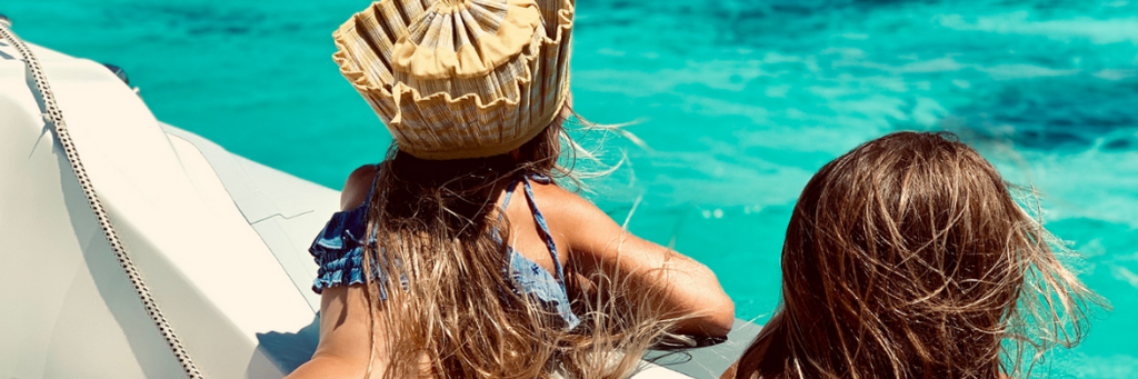 Girls on a boat wearing Lorna Murray Apparel capri sun hats