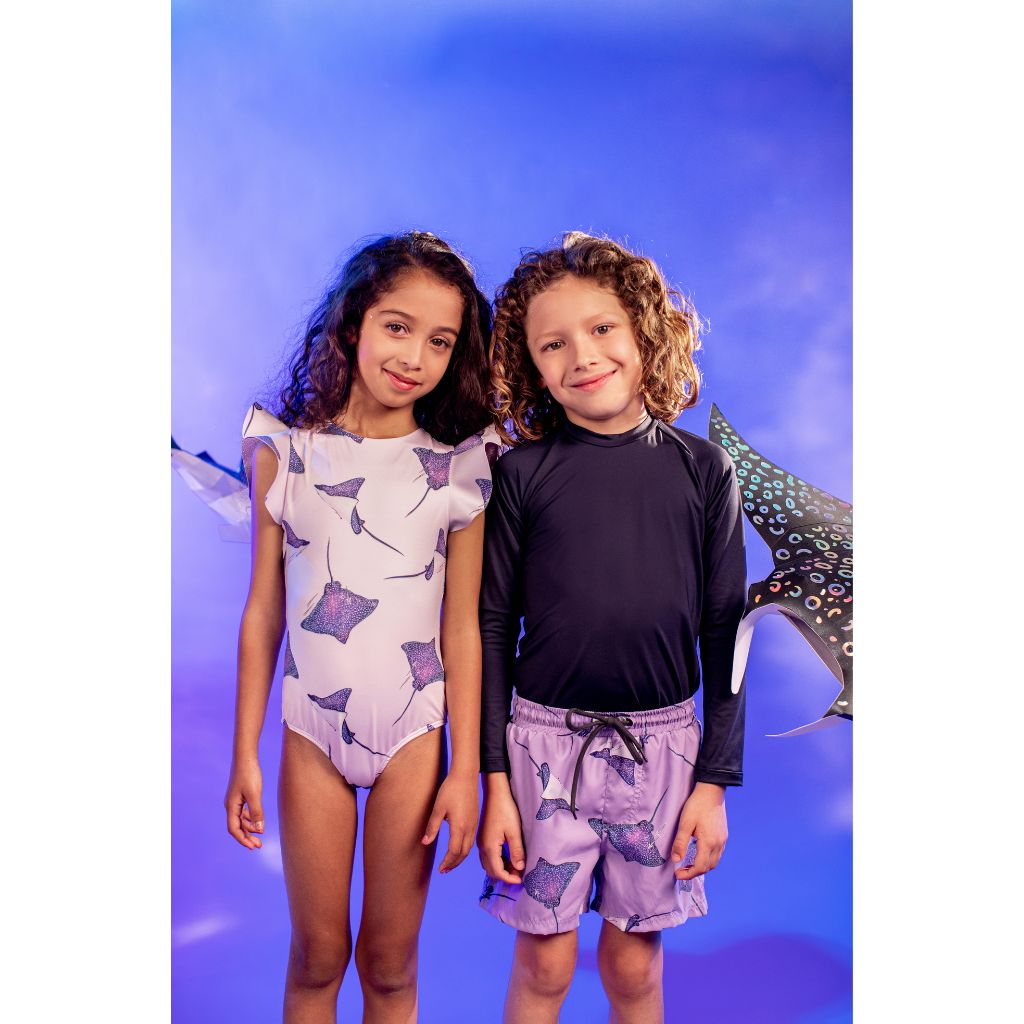 Little boy and girl wearing Pepita & Me  Selena print products from the Tornasol collection including swim shorts and swimsuit