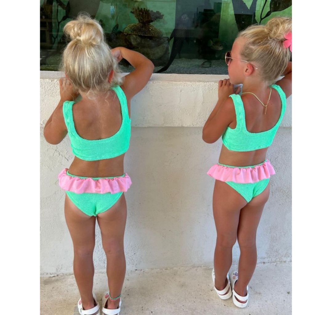 Little girls at the beach wearing the Hunza G Kids Duo Olive Bikini in Lime and Bubblegum