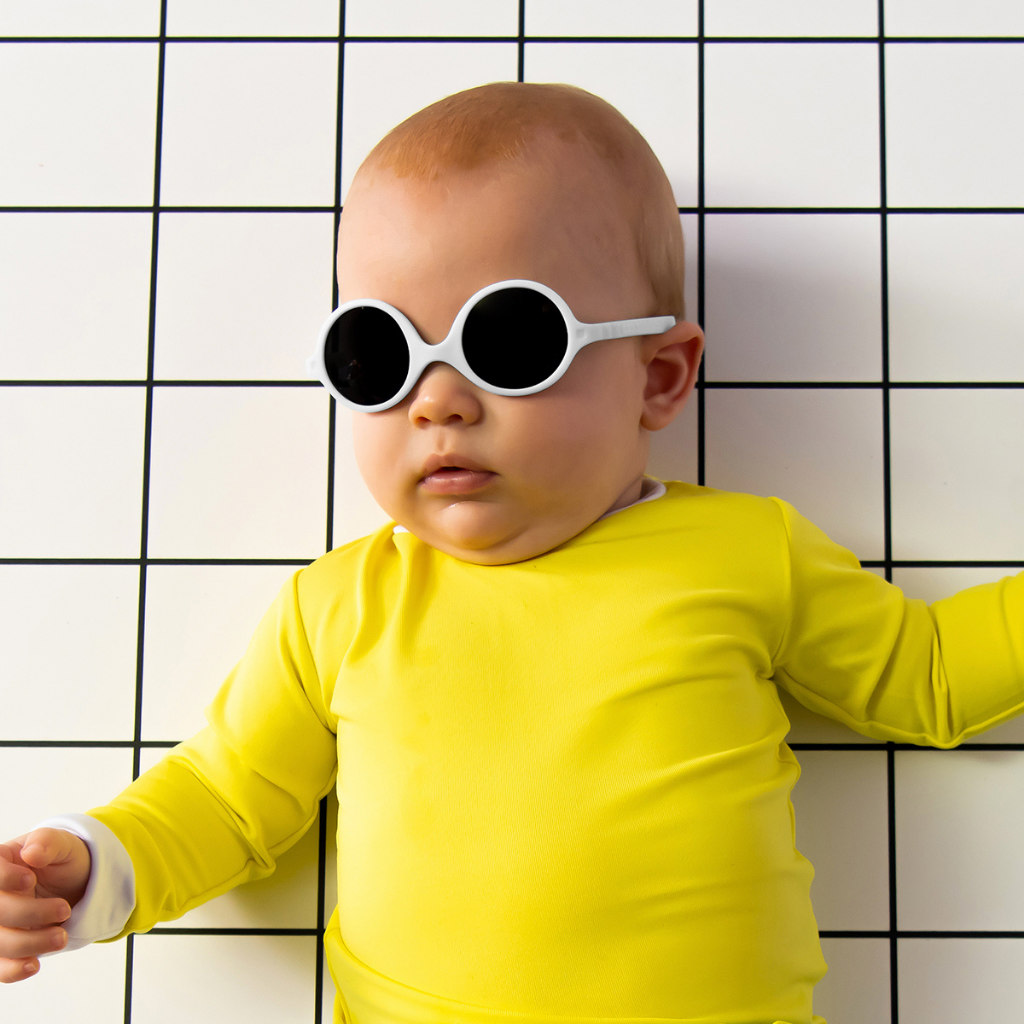 Baby wearing Ki et La Diabola baby sunglasses in white for 0 - 1 years