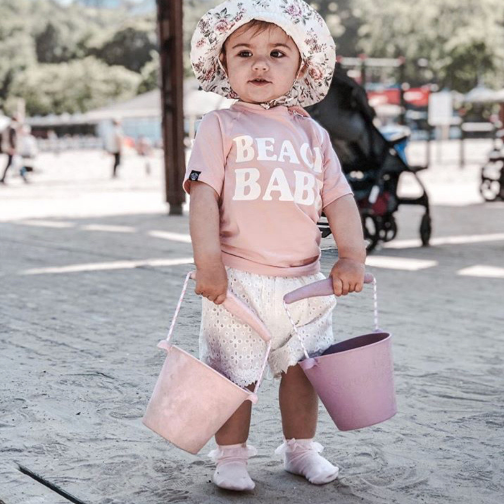 Beach babe carrying her scrunch silicone buckets in old rose and pale lavender