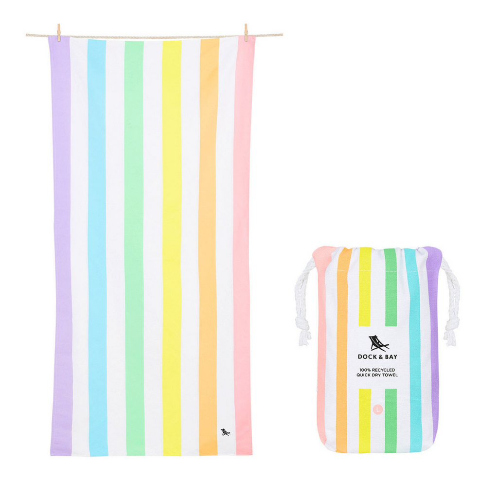 Product image of Dock & Bay Summer Beach Towel in Unicorn Waves featuring pastel hued stripes in purples, blue, green, yellow, orange and pink, complete with protective pouch