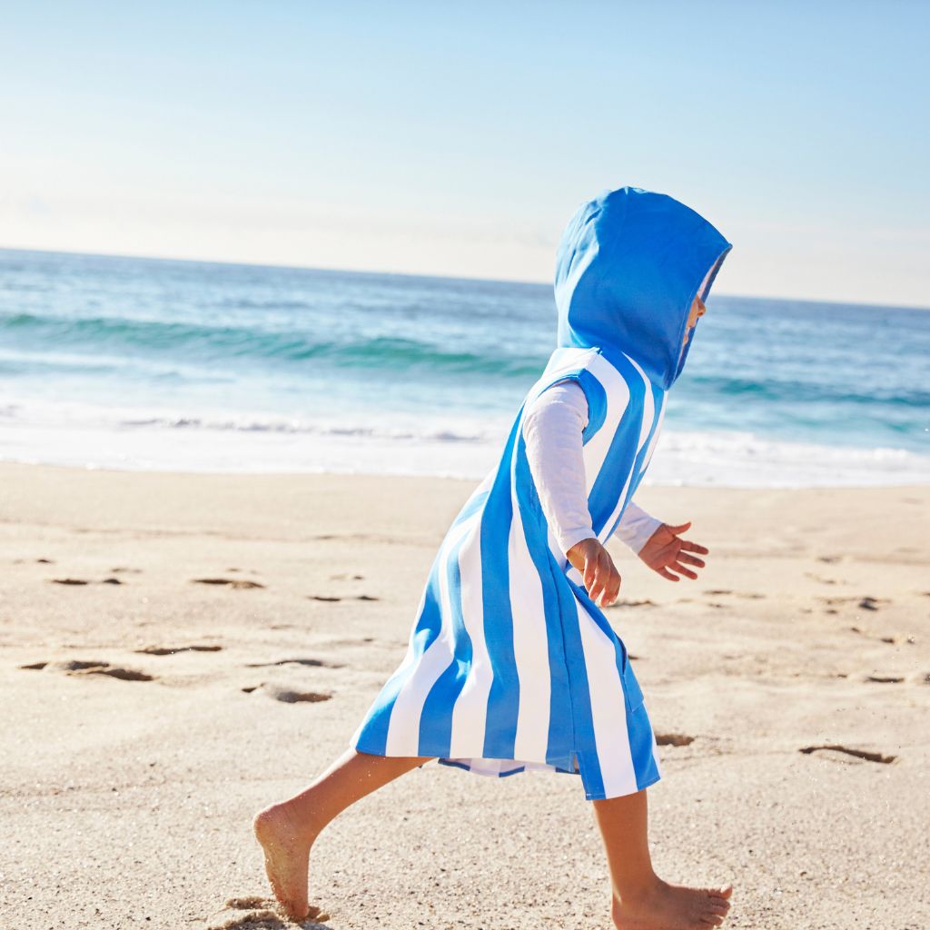 Little boy wearing Dock and Bay kids hooded poncho in Bondi blue 