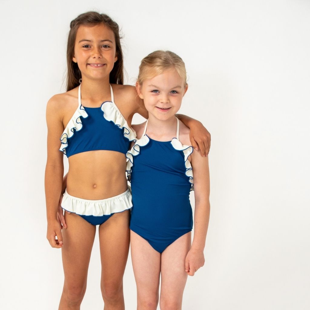 Two little girls wearing SS'22 collection from Folpetto including the Linda swimsuit in night blue and ivory