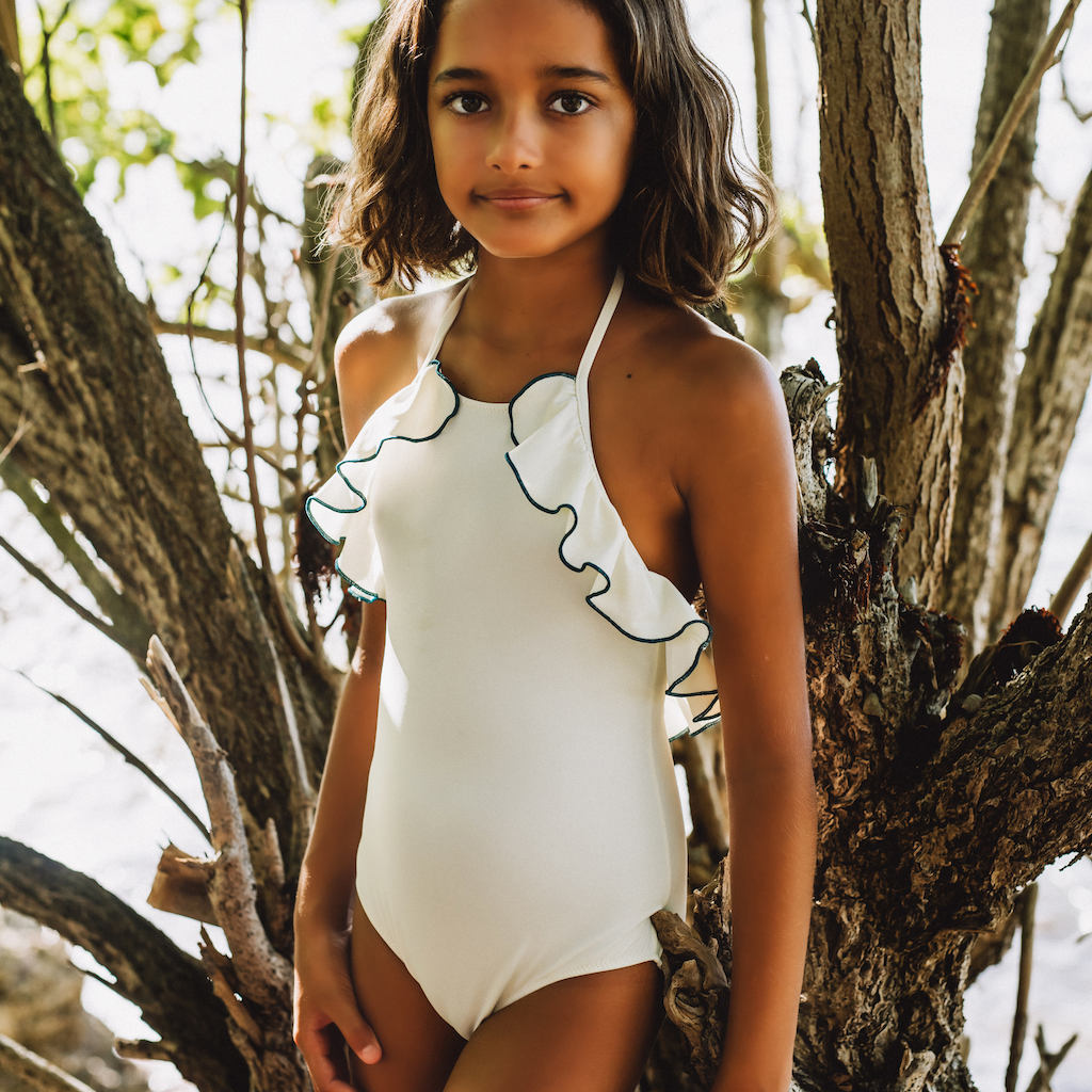 Girl wearing Folpetto linda halterneck girls swimsuit with ruffles in white and teal blue