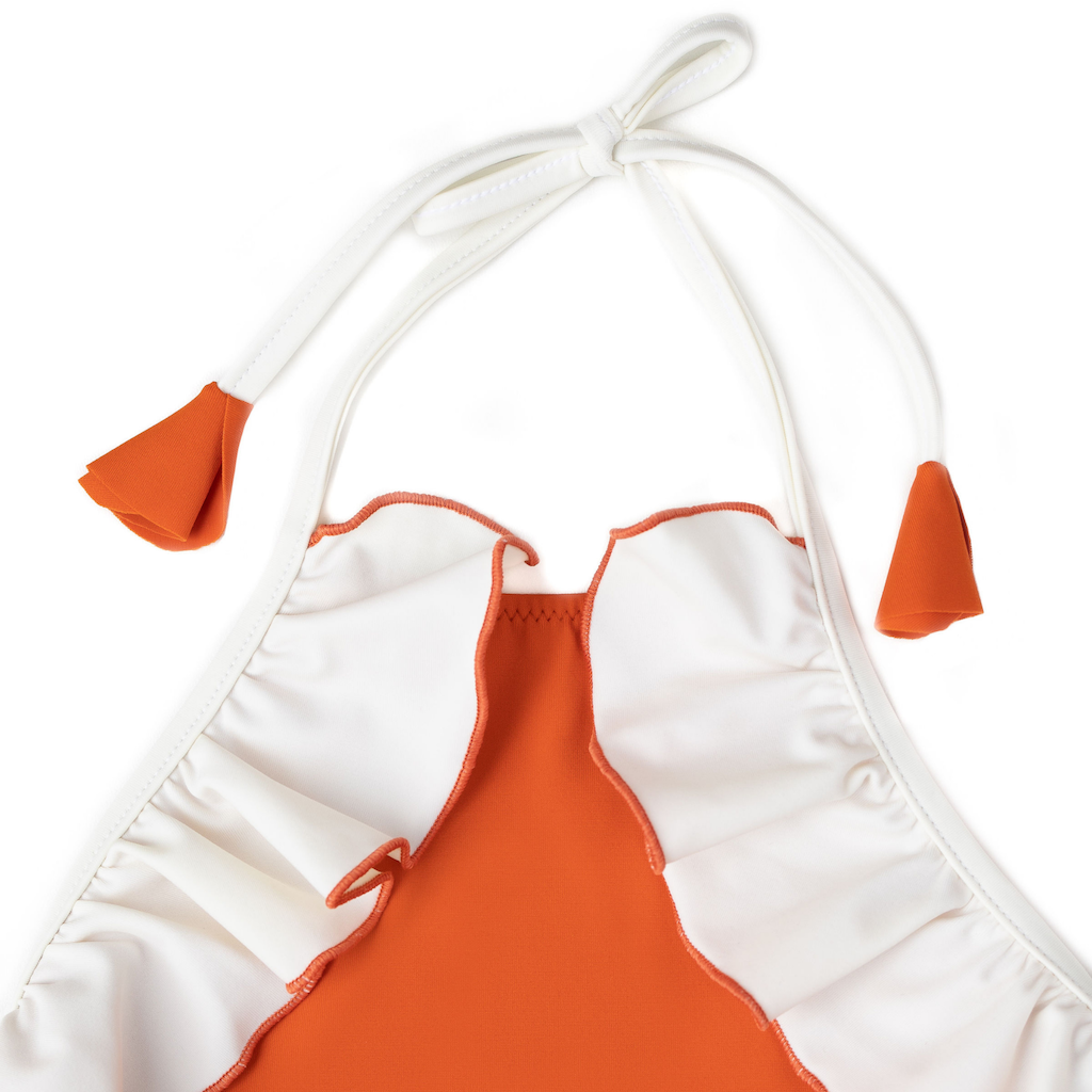 Close up of halter neck on Folpetto linda halterneck girls swimsuit with ruffles in cinnamon orange and white