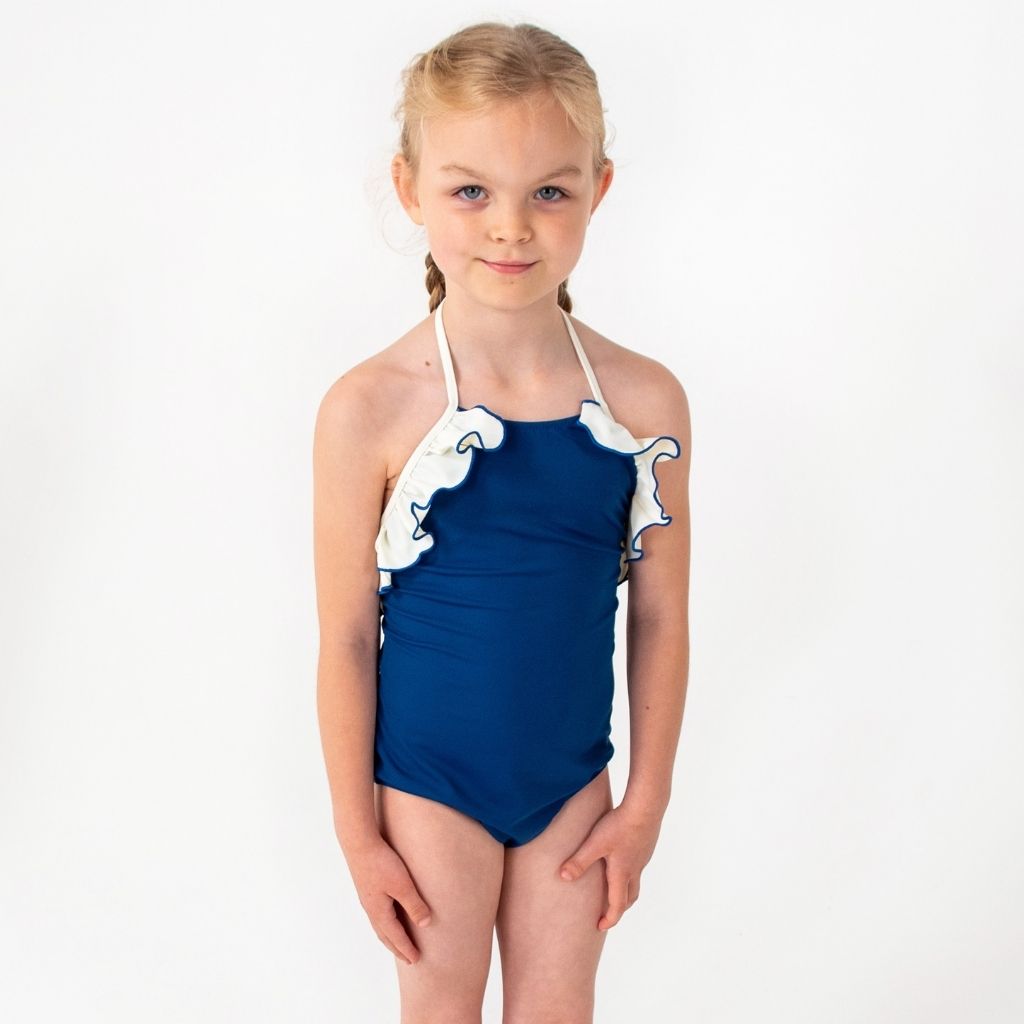 Little girl wearing Linda one piece swimsuit from Folpetto in Night Blue and Ivory