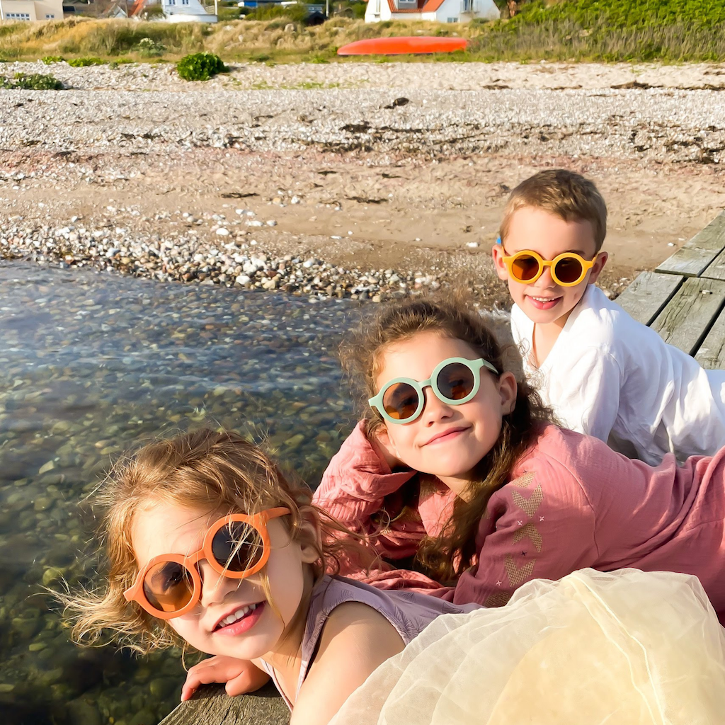Kids relaxing wearing Grech & Co children's sunglasses in golden orange with uv400 protection