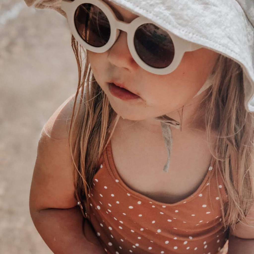 Little girl wearing Grech & Co children's sunglasses in white buff with uv400 protection