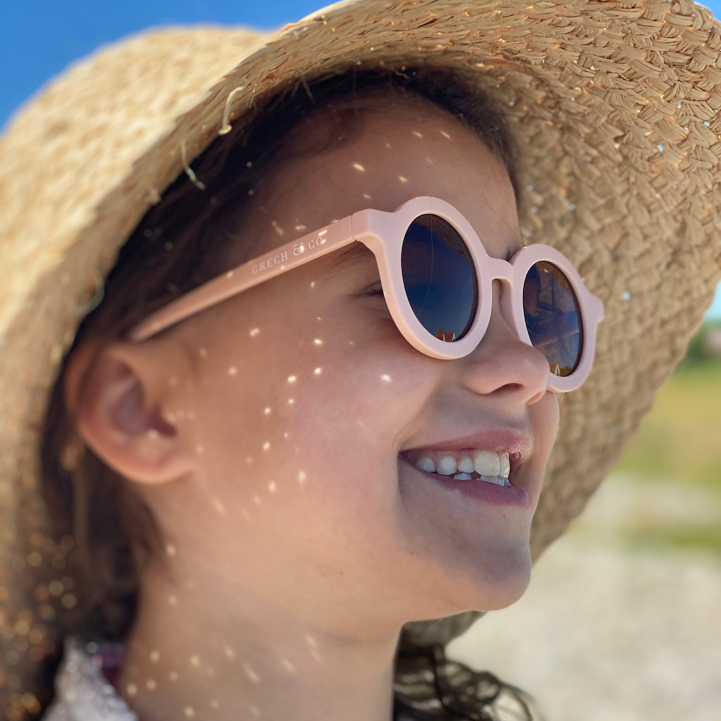 Little girl wearing Grech & Co children's sunglasses in shell pink with uv400 protection