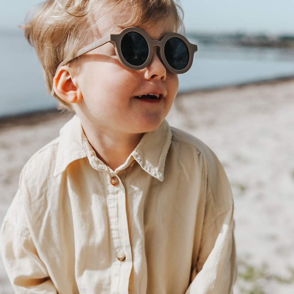 Little boy wearing Grech & Co children's sunglasses in brown stone with uv400 protection