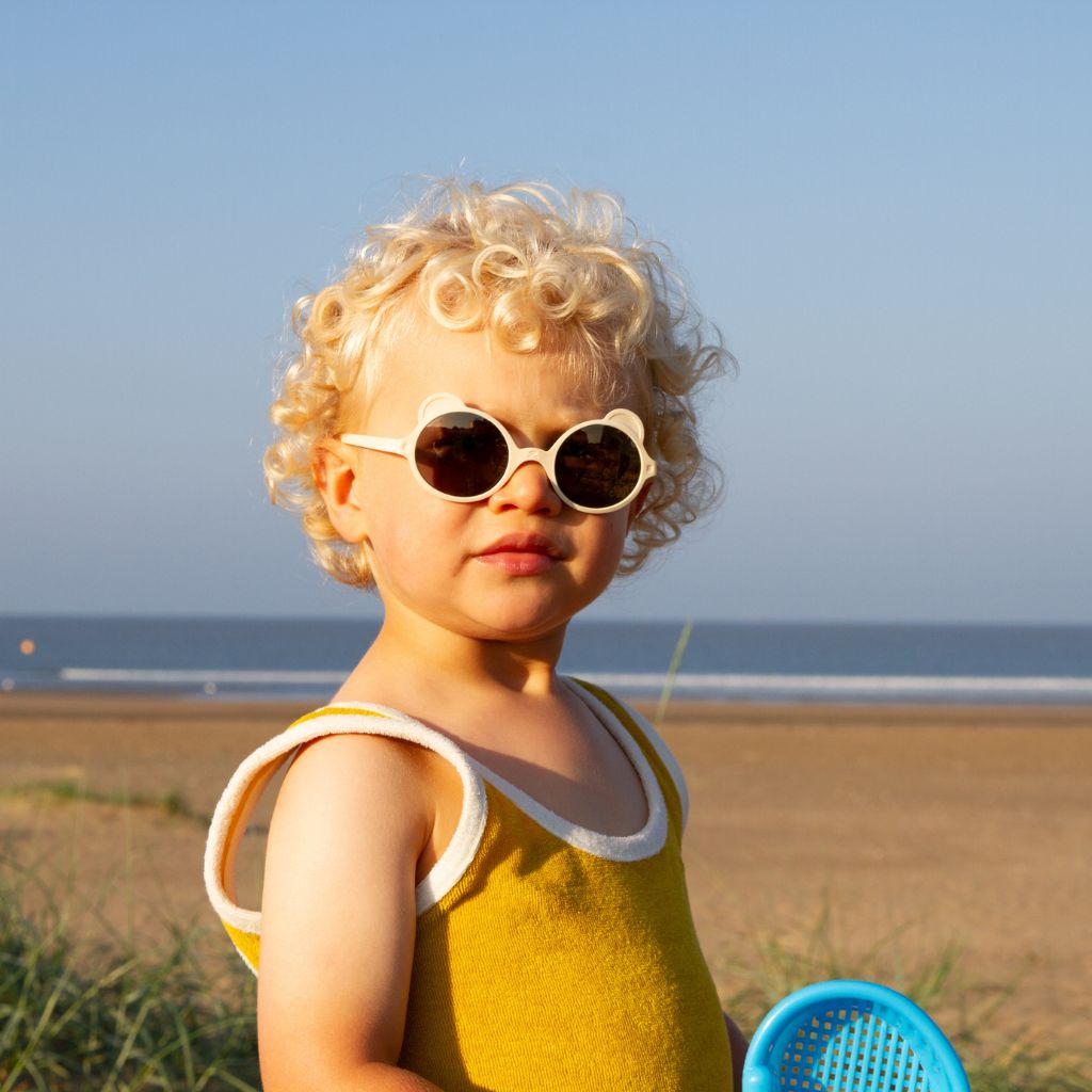 Little boy wearing Ki et La children's Ours'on teddy bear sunglasses in cream