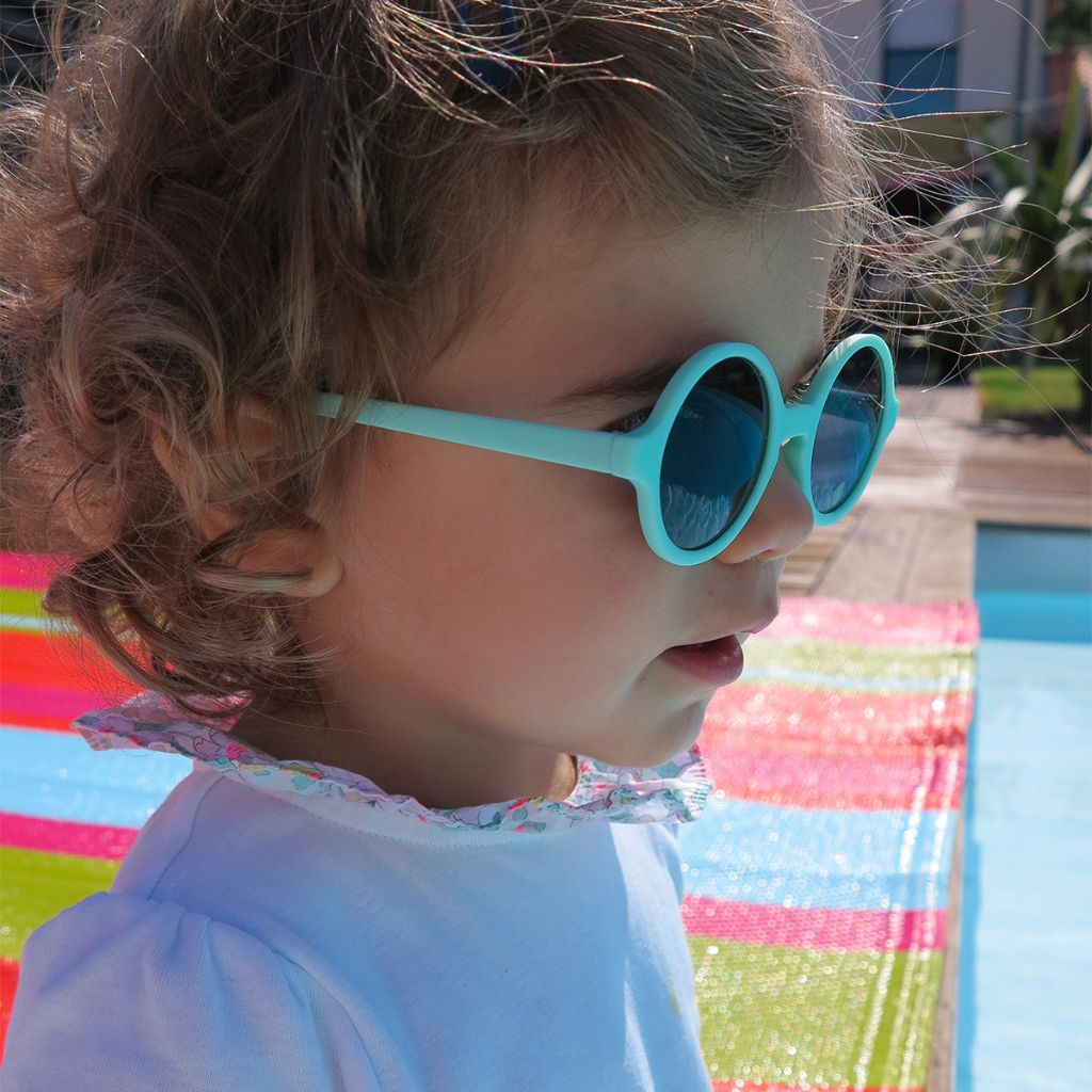 Little girl wearing Ki et La Woam round lens children's sunglasses in bright green