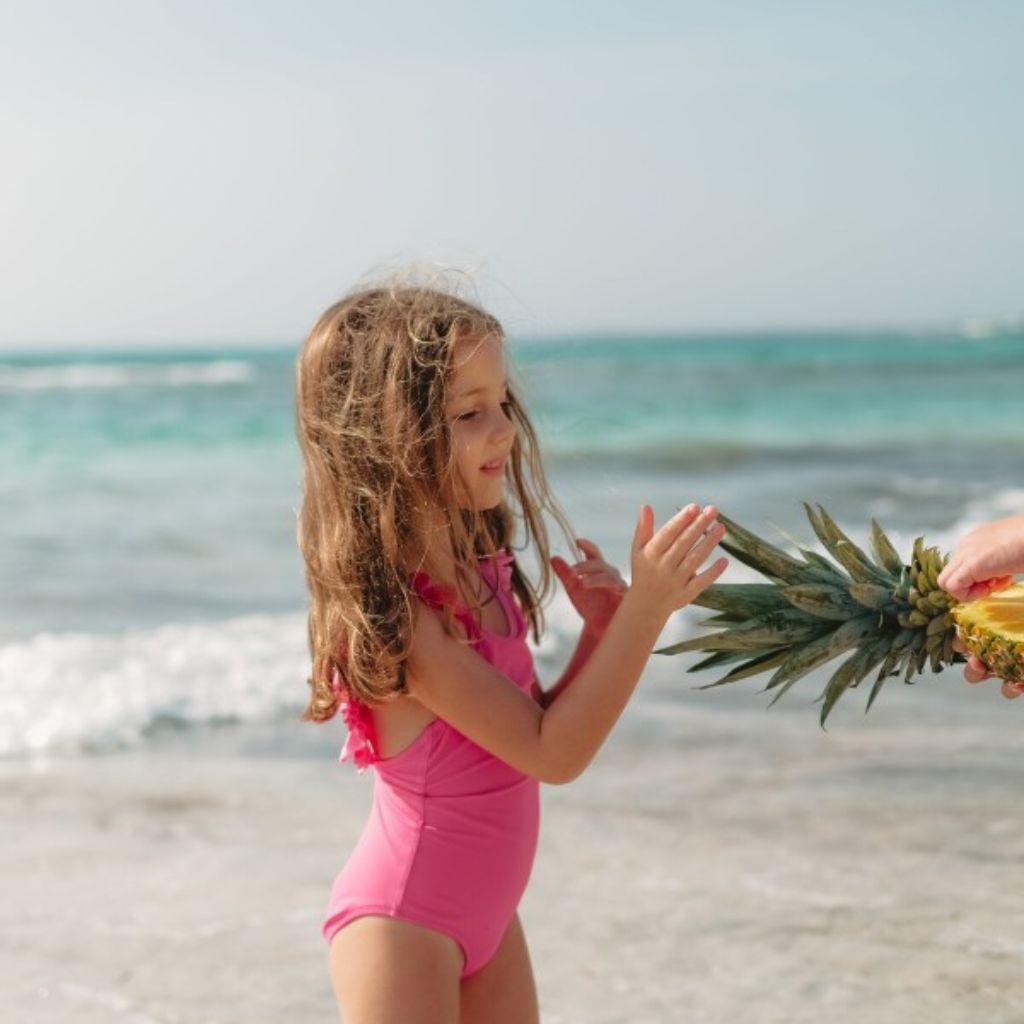 Little girl wearing the Lison Paris best-selling Bora Bora swimsuit in Candy Pink