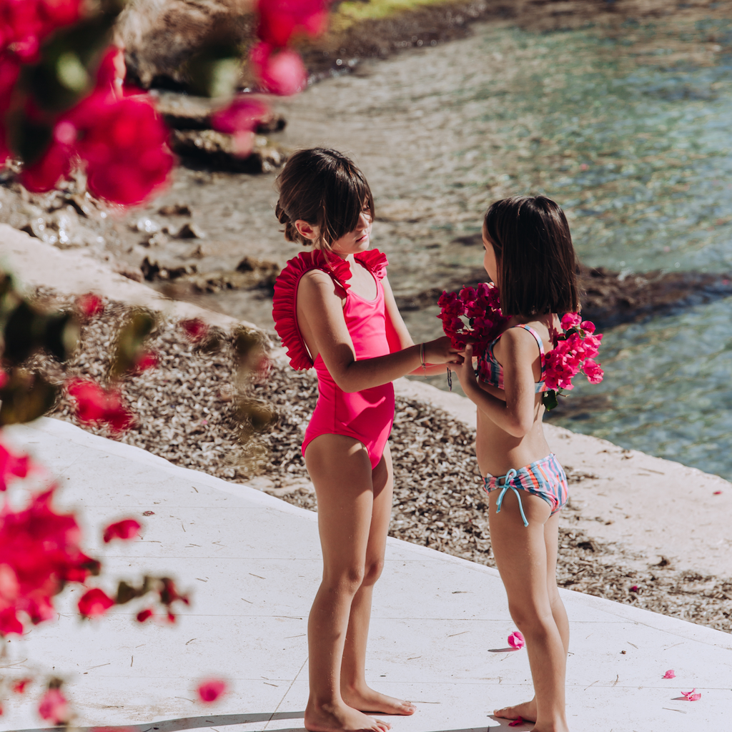 Little girls wearing Lison Paris swimsuits including the Framboise Pink Bora Bora with ruffle detail