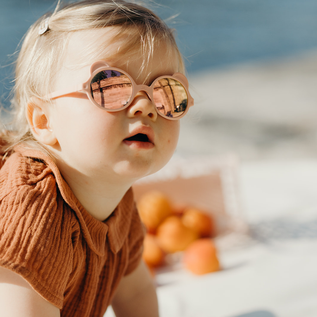 Little girl wearing Ki et La Ourson Teddy Bear sunglasses for Children from 1 - 4 years in Antik Pink