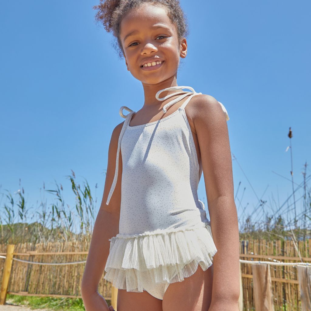 Little girl wearing the Suncracy Ivory Glitter Capri Chic Tulle Swimsuit for baby girls, little girls and older girls