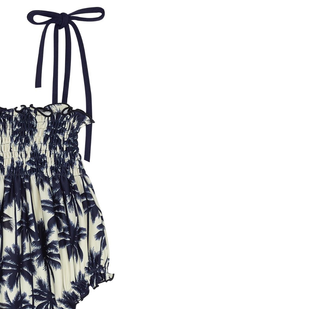 Close up of the Suncracy Palms Menorca Bubble Baby Girls Swimsuit featuring palm tree print