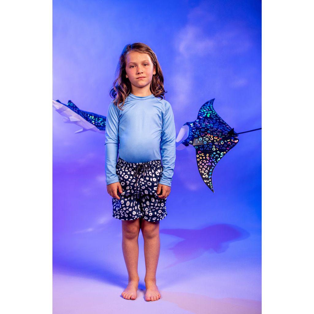 Little boy wearing the Pepita & Me boys swim shorts in Selena Skin Deep Blue pattern from the Tornasol Collection