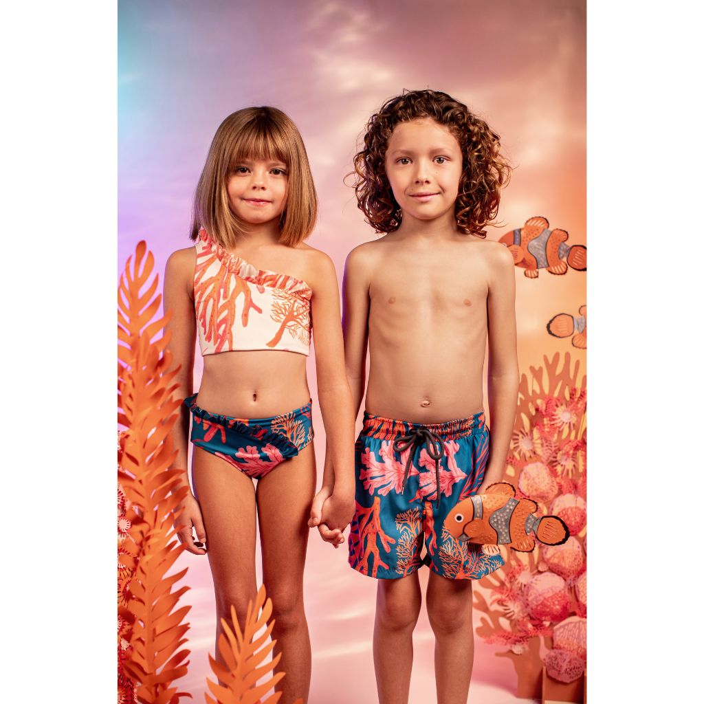 Little boy and girl wearing swim shorts and bikini from the Pepita & Me children's collection including the Corales Mar swim shorts and the Corales Waves bikini from Tornasol collection