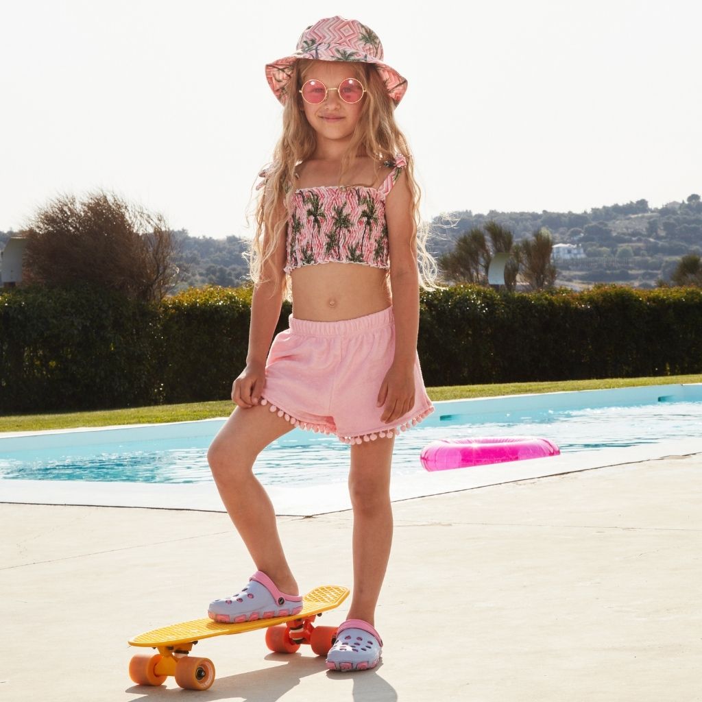 Little girl on her skateboard wearing the Marie Raxevsky towelling shorts in blush