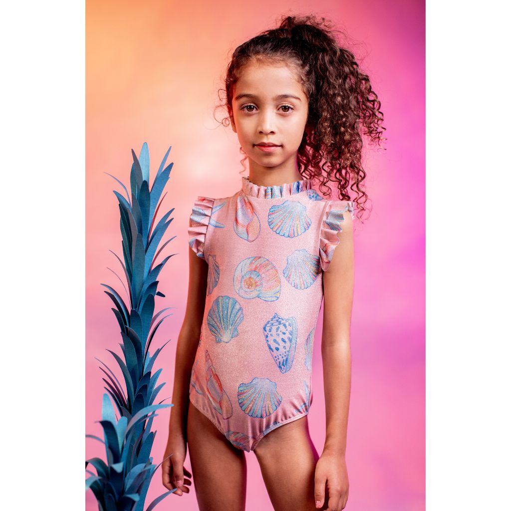 Little girl wearing the Conchas Rosado Brillante Alisson One Piece Swimsuit from the Tornasol Collection of Pepita & Me