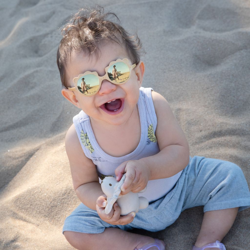 Little boy on the beach wearing the Ki et La Baby Lion Sunglasses in Honey