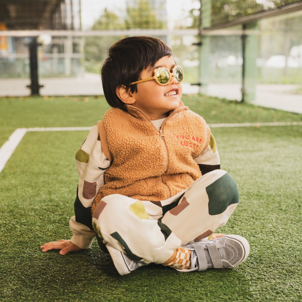 Little boy on the football pitch wearing his Ki et La Lion Sunglasses in Honey