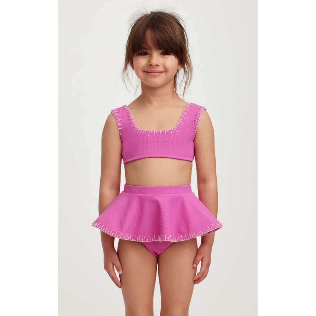 Little girl wearing the Marysia Bumby Trulli Bikini in Orchid with coconut embroidery