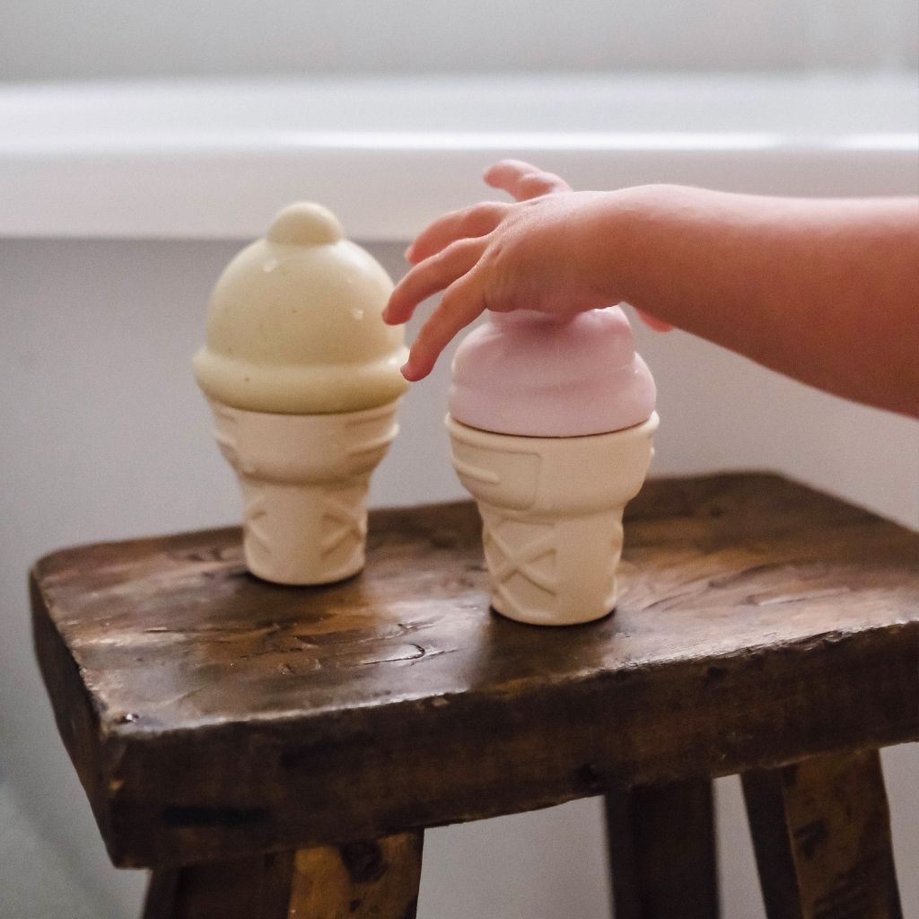 Little hand reaching for the Sunnylife Ice Cream Splash Toys in Apple Sorbet