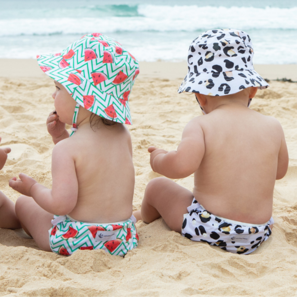 Babes on the beach wearing Anchor & Arrow Frolicking Watermelon and Leopard Print unisex reusable swim nappy