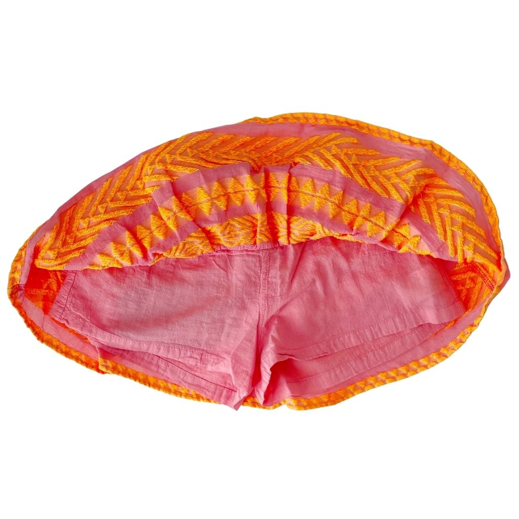 The concealed shorts inside the Snow White skirt in neon orange and neon pink from the children's line of Greek resort wear brand, Devotion Twins