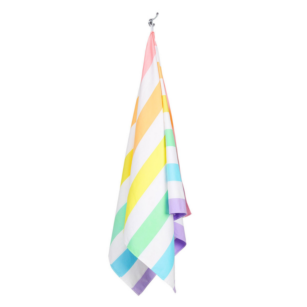 Image of hanging Dock & Bay Summer Beach Towel in Unicorn Waves featuring pastel hued stripes in purples, blue, green, yellow, orange and pink
