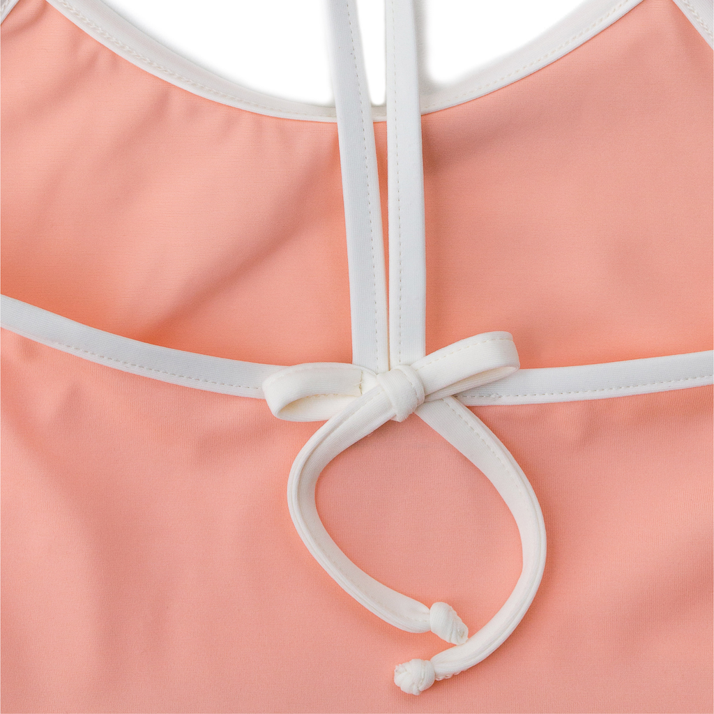 Close up of Folpetto Amelia swimsuit in peach pink
