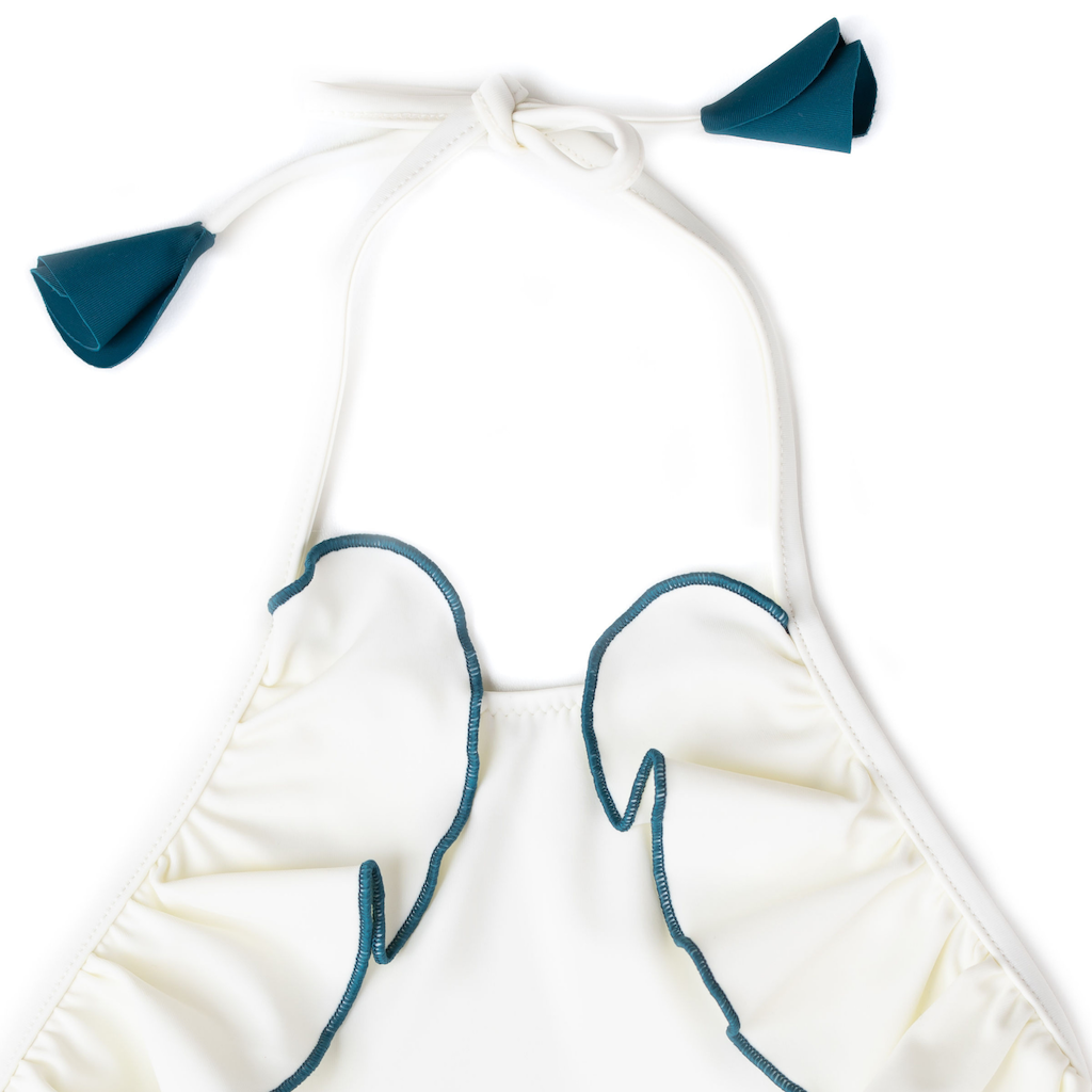 Close up of Folpetto linda halterneck girls swimsuit with ruffles in white and teal blue