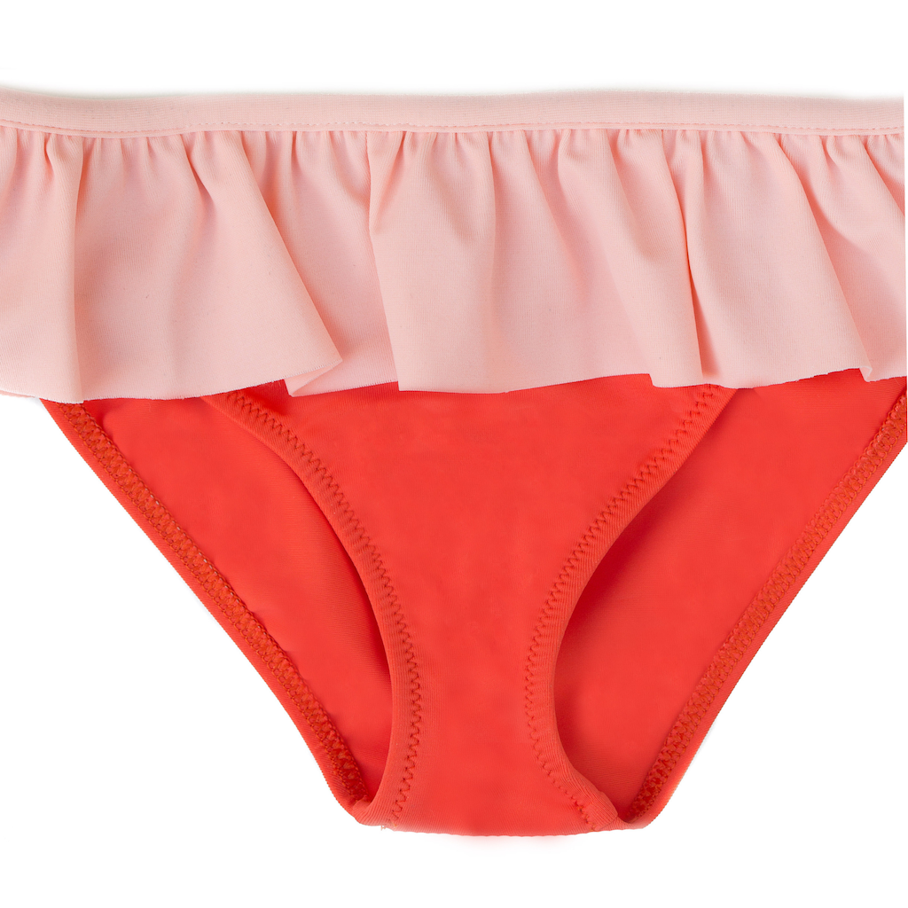 Close up of Folpetto Maia one shouldered bikini for girls in mandarin red with peach pink ruffle