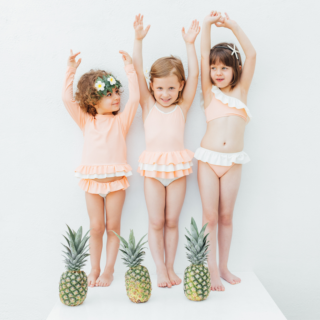 Three little girls wearing Folpetto alice swim pants for girls in peach pink