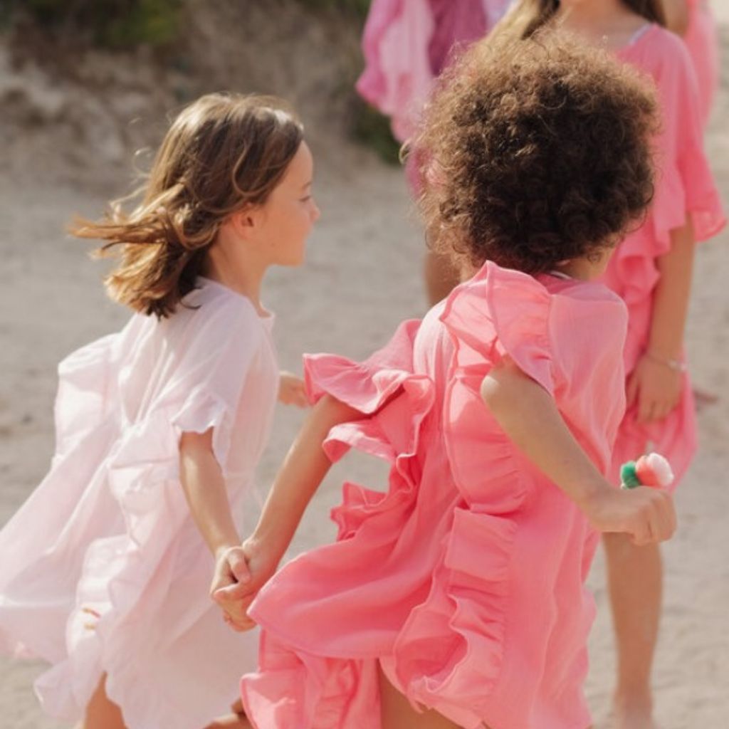 Little girl wearing the Lison Paris lea kaftan in fluo pink