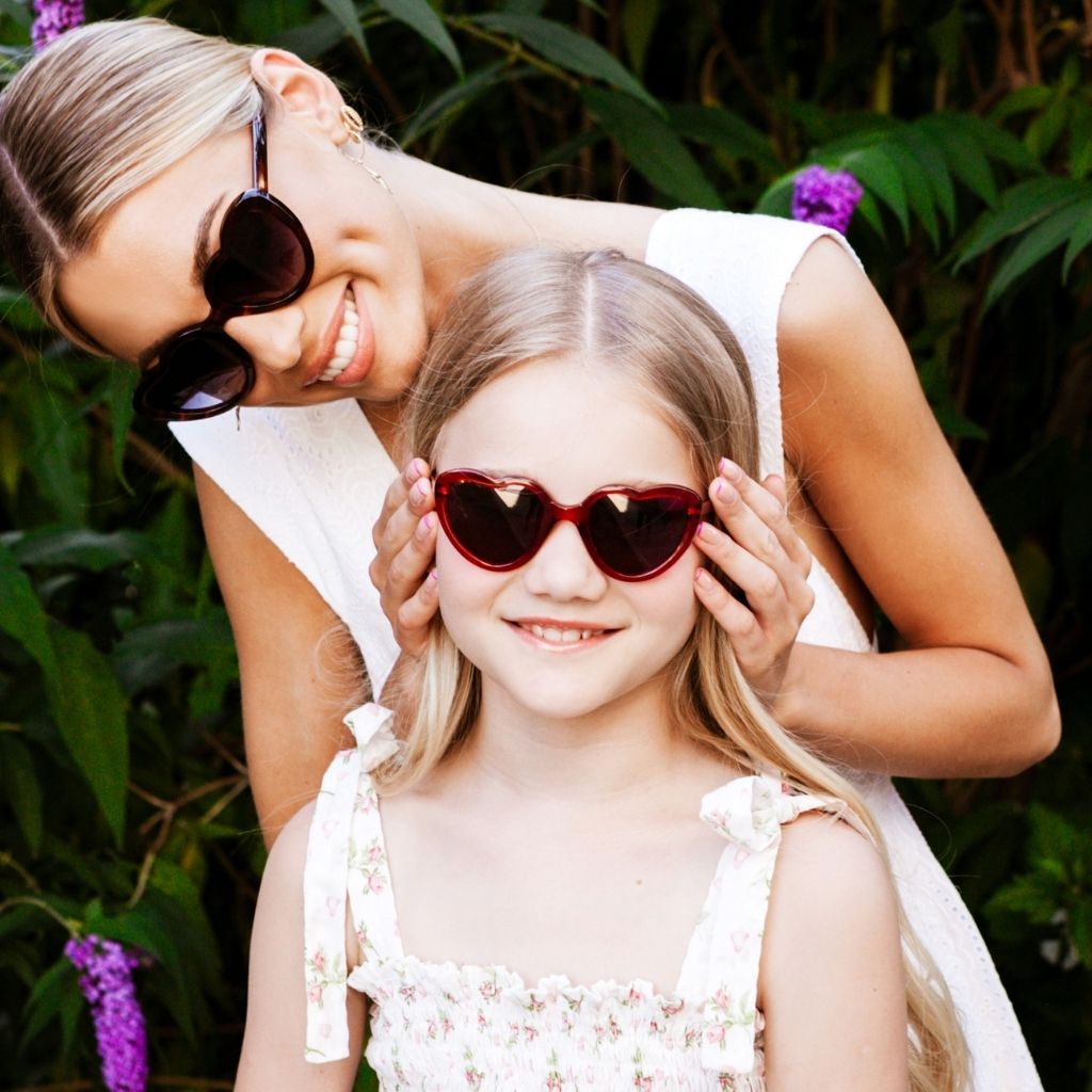 Little girl with her mum wearing the Juli red crystal heart sunglasses from Maison Juli