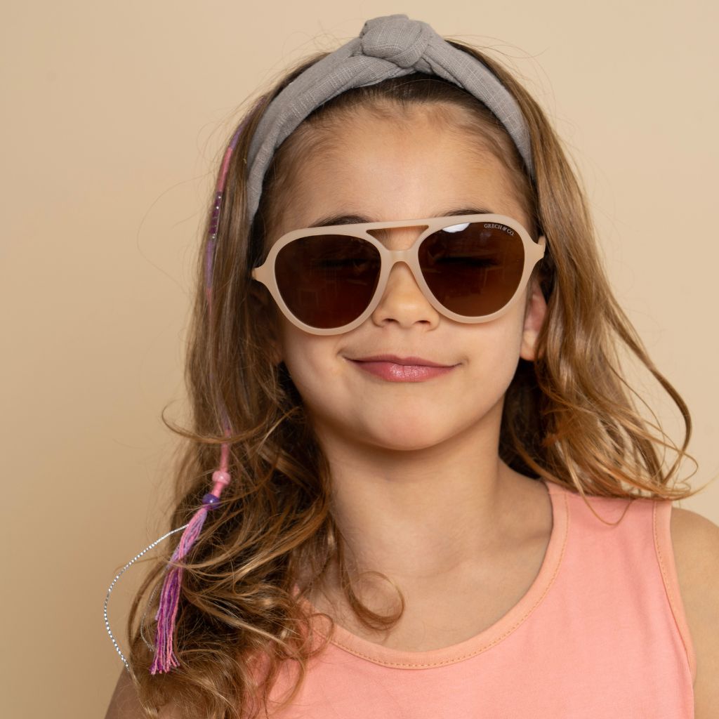 Little girl wearing the gorgeous Grech and Co Aviator Polarised Sunglasses for babies, toddlers and children in creamy white