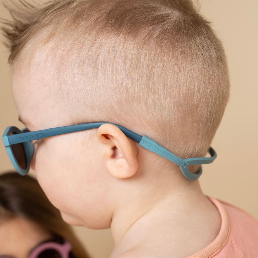 Little boy wearing Grech & Co baby sunglasses strap in sky blue
