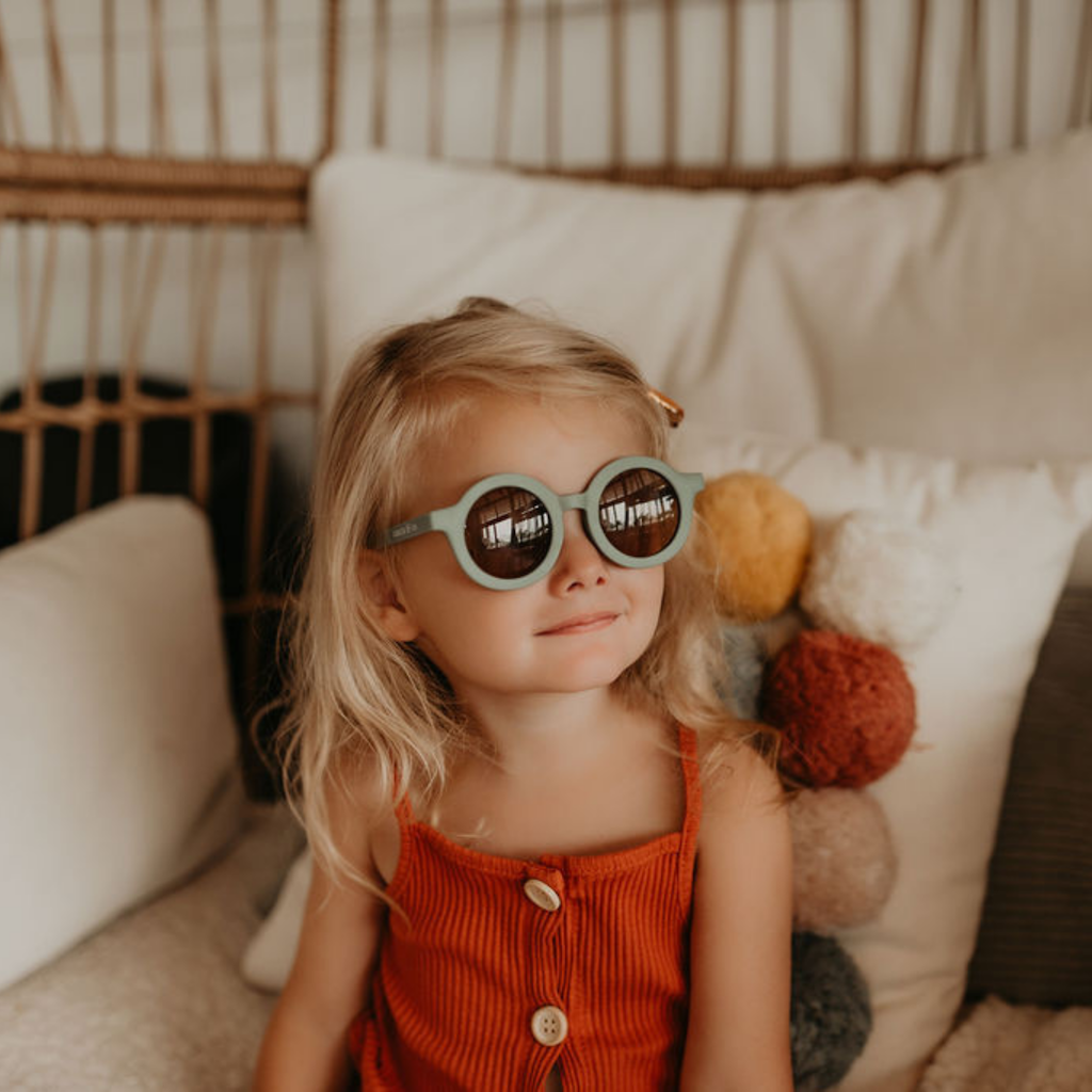 Little girl wearing Grech & Co children's sunglasses in light blue with uv400 protection