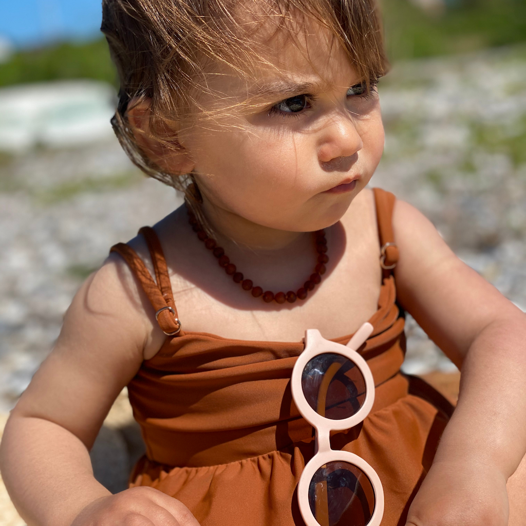 Baby girl wearing Grech & Co children's sunglasses in shell pink with uv400 protection