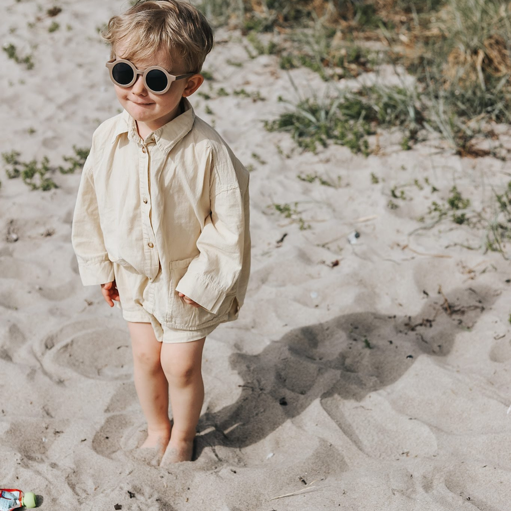 Little boy wearing Grech & Co children's sunglasses in brown stone with uv400 protection