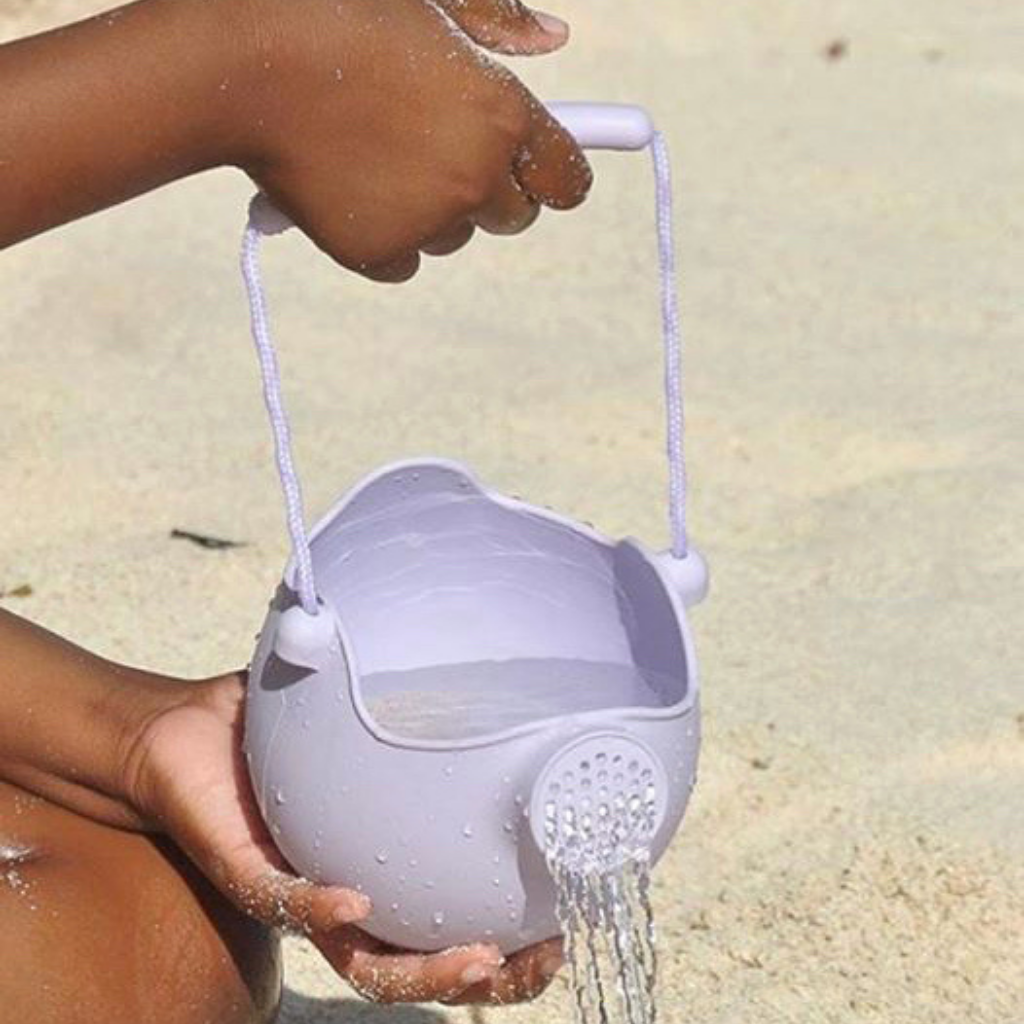 Hand holding Scrunch silicone watering can in pale lavender