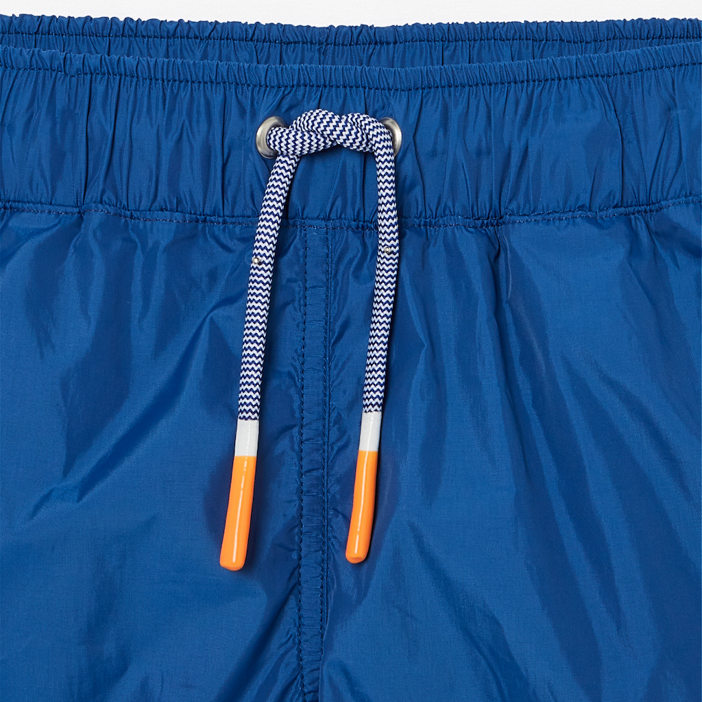 Close up of orange drawstring detail on Lison Paris boys Capri swim shorts in blue