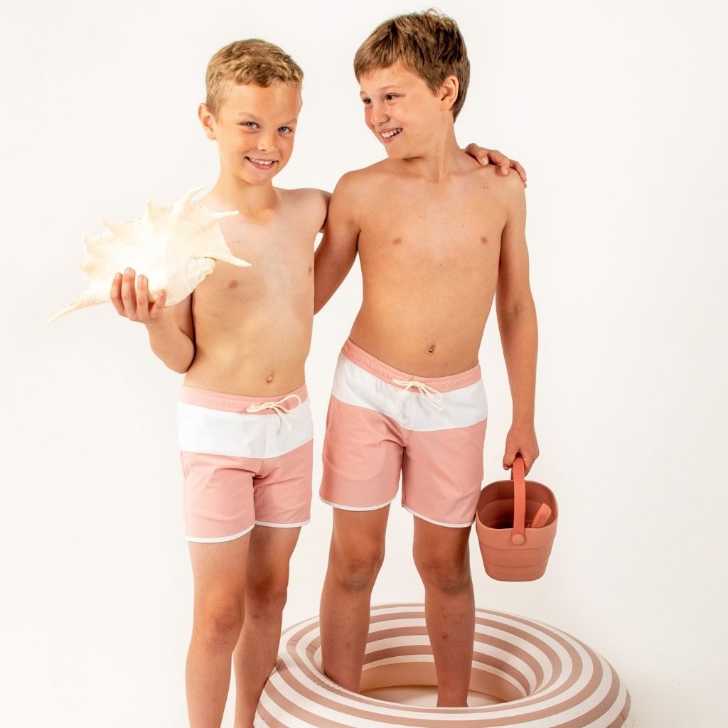 Two boys wearing the Folpetto Jack swim shorts in dusty pink and ivory